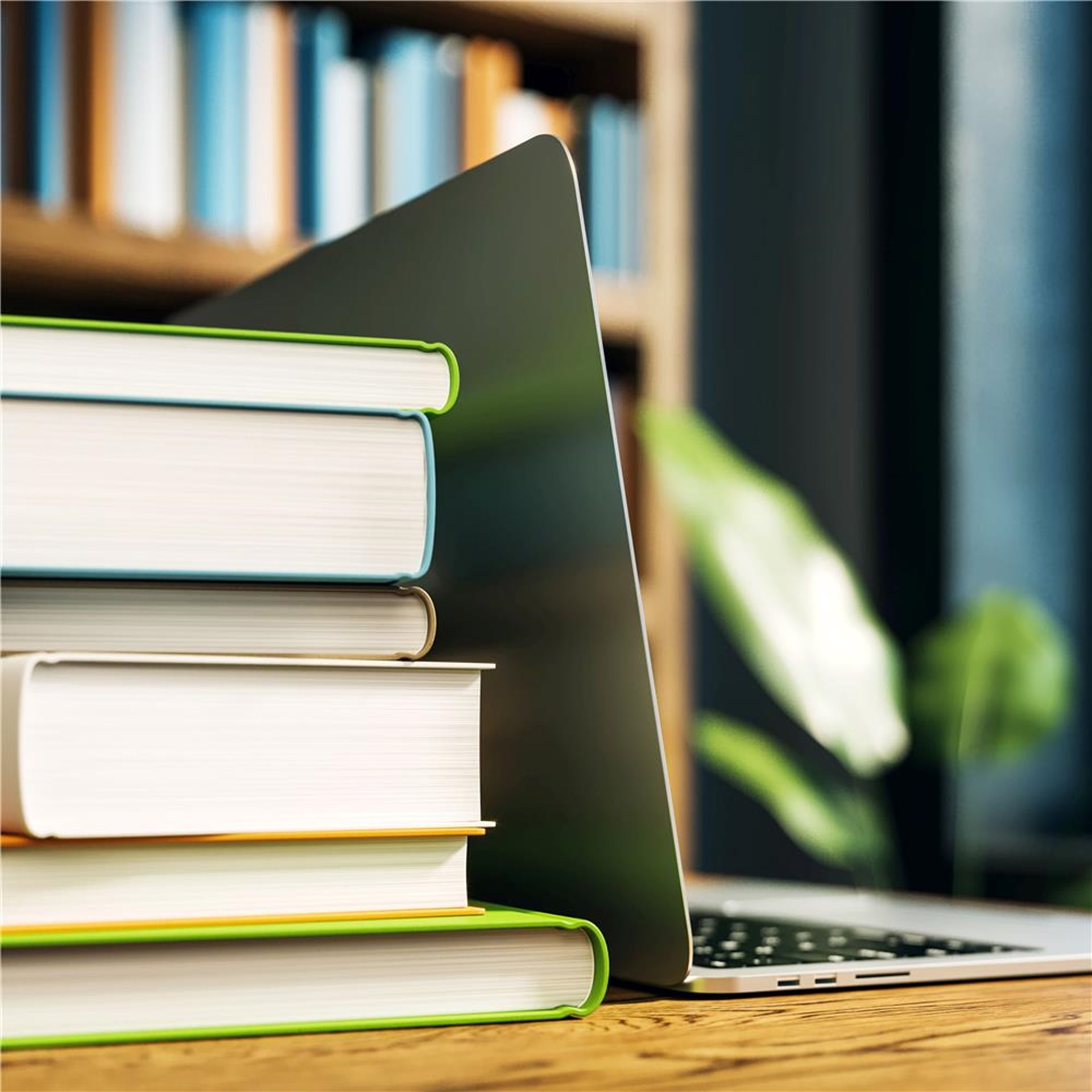 Bücher und ein Laptop auf einem Bürotisch