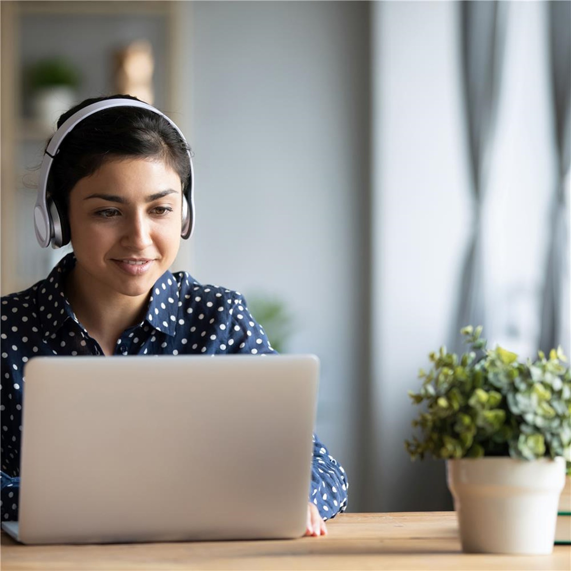 Junge Frau mit Kopfhörer am Laptop